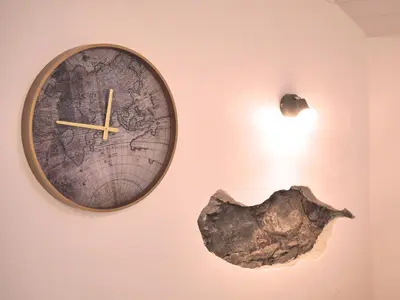 a clock hanging on a wall with a map at Casa do pescador in Machico
