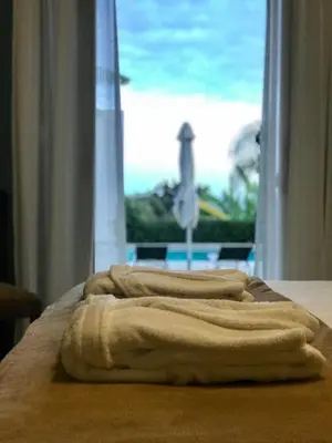 a towel sitting on a bed in front of a window at Bordal Houses in Funchal