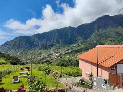 a house on a hill with mountains in the background at Matilde House in São Vicente