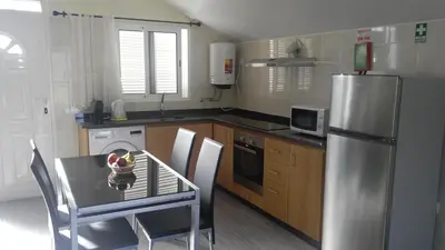 a kitchen with a table and a stainless steel refrigerator at Matilde House in São Vicente