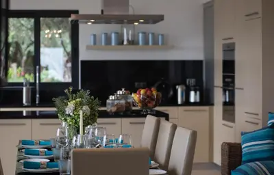 a kitchen with a table with chairs and a dining room at Luxury Ocean Front Villla in Calheta