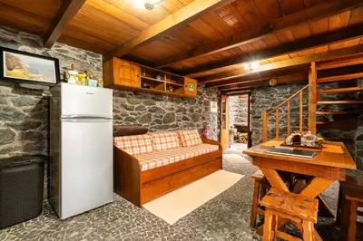a room with a refrigerator and a bench in a kitchen at King's House - Centennial House in Arco da Calheta