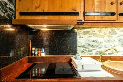a kitchen with a counter with a stove top oven at King's House - Centennial House in Arco da Calheta