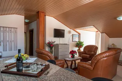 a living room with a table and leather chairs at Apartment lucy in Arco da Calheta