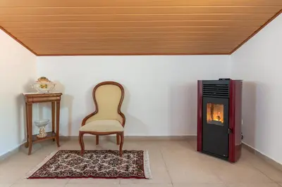 a chair and a fireplace in a room at Apartment lucy in Arco da Calheta
