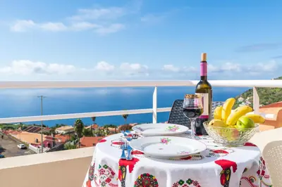 a table with a plate of food and a bottle of wine at Apartment lucy in Arco da Calheta