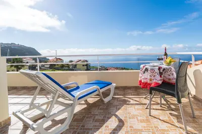a balcony with a table and chairs and the ocean at Apartment lucy in Arco da Calheta