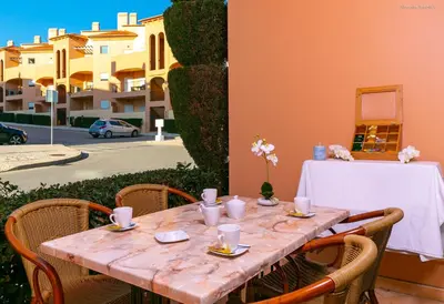 a wooden table with chairs and a table cloth on it at LuzBay Pool Apartments in Luz