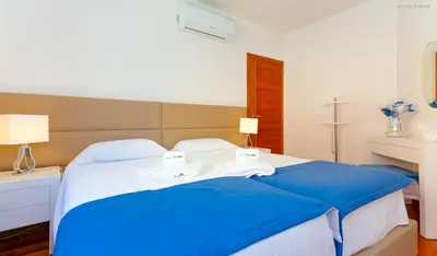 a bedroom with a blue bed with towels on it at LuzBay Pool Apartments in Luz