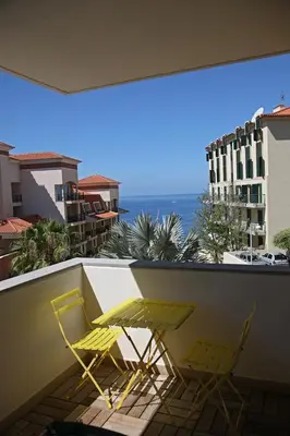 two chairs on a balcony with a view of the ocean at Formosa Infinity Pool Apartment in Funchal