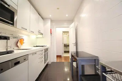 a kitchen with white cabinets and a black counter top at Formosa Infinity Pool Apartment in Funchal