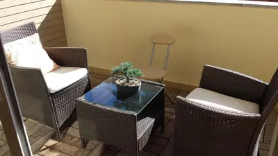 a patio with chairs and a table with a plant on it at Formosa Infinity Pool Apartment in Funchal