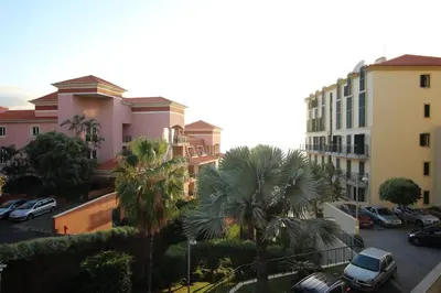 a view of a parking lot with palm trees and buildings at Formosa Infinity Pool Apartment in Funchal