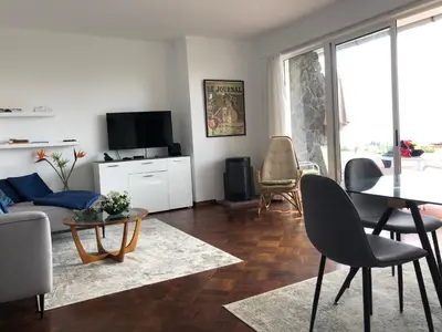 a living room with a couch and a table and chairs at Casa Palmeira - Ferienhaus mit Meerblick in Caniço