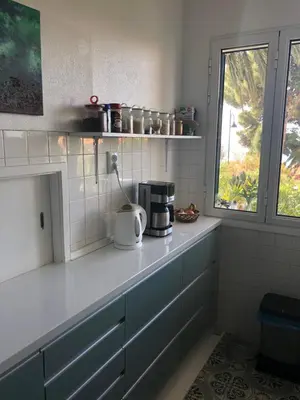 a kitchen with blue cabinets and a window at Casa Palmeira - Ferienhaus mit Meerblick in Caniço
