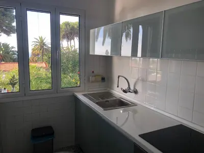 a bathroom with a sink and two windows at Casa Palmeira - Ferienhaus mit Meerblick in Caniço