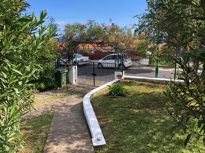 a garden with a metal fence and a gate at Casa Palmeira - Ferienhaus mit Meerblick in Caniço
