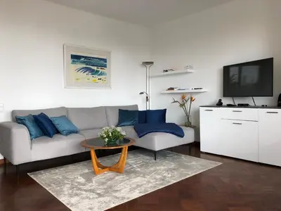a living room with a couch and a tv at Casa Palmeira - Ferienhaus mit Meerblick in Caniço