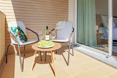 two chairs and a table with a bottle of wine and grapes at Apartment Formosa - Infinity pool in Funchal