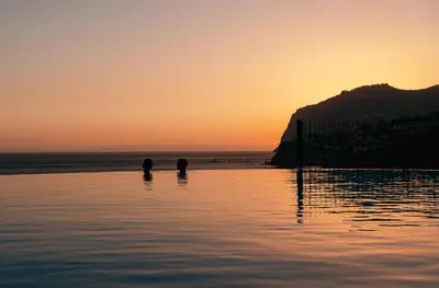 two people standing in the water at the beach at Apartment Formosa - Infinity pool in Funchal