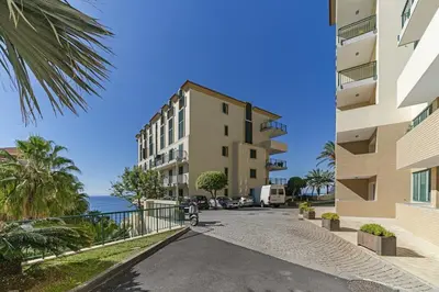 a street in front of a building next to the ocean at Apartment Formosa - Infinity pool in Funchal