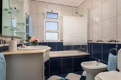 a bathroom with a sink and a toilet and a tub at Villa Neto in Calheta