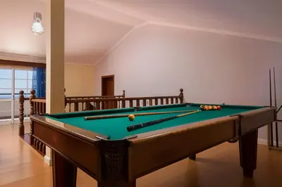 a pool table in a living room with a pool at Villa Neto in Calheta