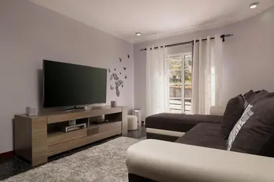 a living room with a flat screen tv on a wooden entertainment center at Villa Neto in Calheta