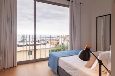 a bedroom with a bed and a large window at Solar do Ribeiro in Funchal