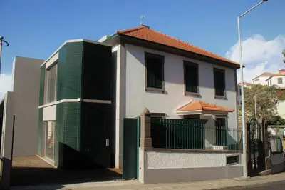 a white house with green doors and a fence at Solar do Ribeiro in Funchal