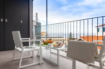a white table and chairs on a balcony with a view at Solar do Ribeiro in Funchal