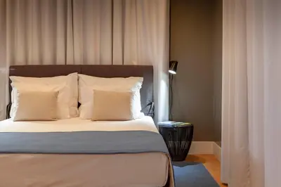 a bedroom with a bed with white sheets and pillows at Solar do Ribeiro in Funchal