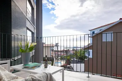 a balcony with a table and a view of a city at Solar do Ribeiro in Funchal