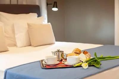 a tray with coffee cups and pastries on a bed at Solar do Ribeiro in Funchal