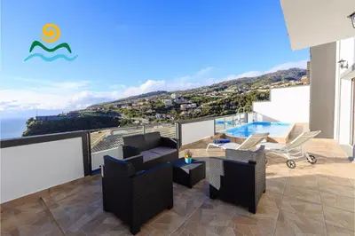 a balcony with furniture and a view of the ocean at OurMadeira - Casa da Belita in Calheta