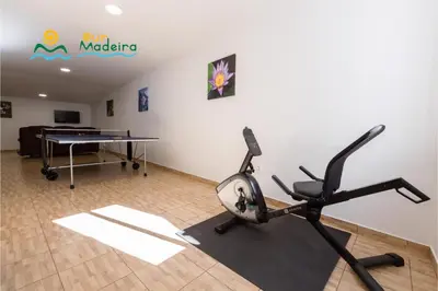 a gym with a ping pong table and a treadmill at OurMadeira - Casa da Belita in Calheta