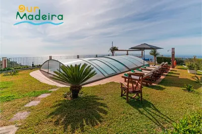 a bedroom with a large bed and a couch at OurMadeira - Theo's House in Calheta