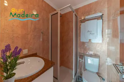 a bathroom with a sink and a toilet and a shower at OurMadeira - Theo's House in Calheta