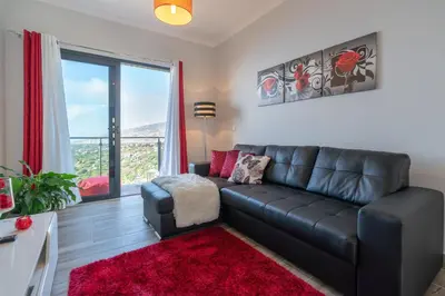 a living room with a leather couch and a red rug at Casa das Abertas in Calheta