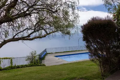 a house with a swimming pool in front of a house at Casa da Manta in Fajã da Ovelha