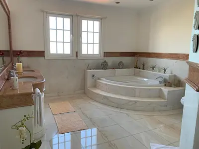 a large bathroom with a tub and a sink at Vila Tagus Garajau in Caniço