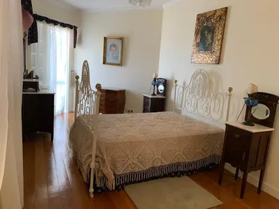 a bedroom with a bed and a wooden floor at Vila Tagus Garajau in Caniço
