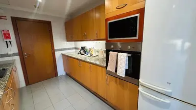a kitchen with wooden cabinets and a white refrigerator at Apto Barreiro by Susy's Holidays in Funchal