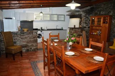 a kitchen with white cabinets and a washing machine at Solar Arco de São Jorge in Santana