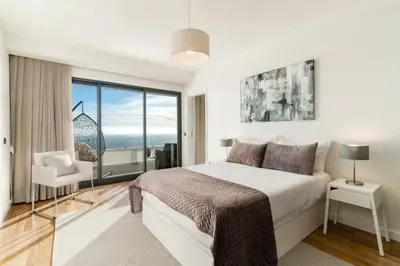 a bedroom with a bed and a large window at Sky Villa by An Island Apart in Funchal