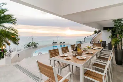 a dining room with a table and chairs and a swimming pool at Sky Villa by An Island Apart in Funchal