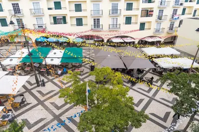 an overhead view of an outdoor market with tables and umbrellas at Funchal Village Studios in Funchal