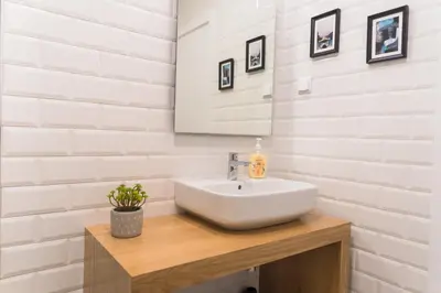 a white bathroom with a sink and a mirror at Funchal Village Studios in Funchal