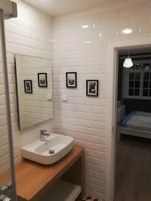 a bathroom with a sink and a mirror and a bed at Funchal Village Studios in Funchal