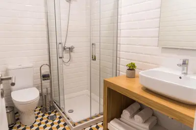 a bathroom with a shower and a sink and a toilet at Funchal Village Studios in Funchal